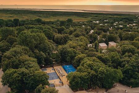 Aerial view with tennis court, playing field and holiday homes at Roompot Vakantiepark Kijkduin