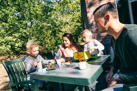 Family at the table in the garden of a holiday home at Roompot Vakantiepark Weerterbergen