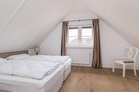 Bedroom with a double bed in a holiday home at the Roompot Villaparc Schoonhovenseland