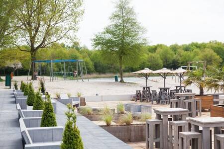 Terrace and playground at the recreational lake next to Roompot Villaparc Schoonhovenseland