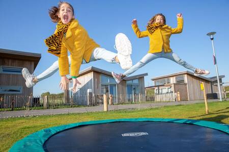 Children jump on a trampoline at a holiday home at the Roompot Water Village holiday park