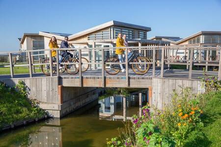 People on a bridge and holiday homes at the Roompot Water Village holiday park