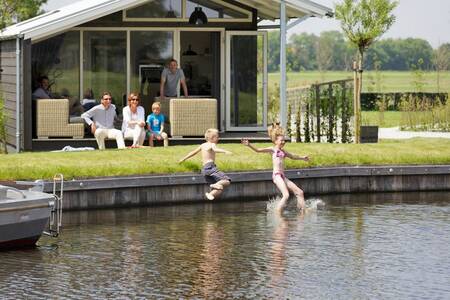 People in the garden of a holiday home at the Roompot Waterpark Terkaple . holiday park