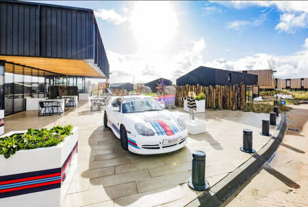 A Porsche is parked outside the Roompot Zandvoort restaurant