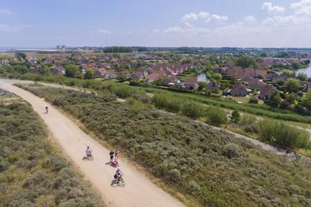 People cycle through the dunes next to the Roompot Zeebad holiday park