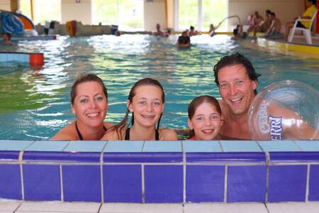 Family is swimming in the indoor pool of the Roompot Zeebad holiday park