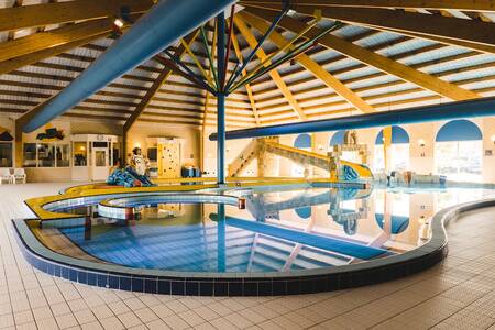 The indoor pool with water slide at the Roompot Zeebad holiday park