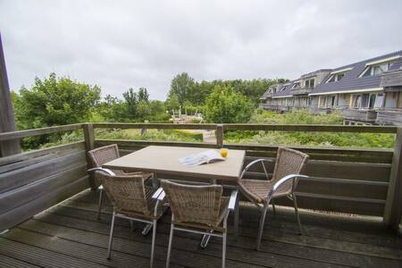 Table with chairs on the balcony of an apartment at Résidence Terschelling