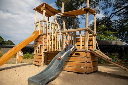 Little boy on the slide in the playground at Soof Retreats Soof Heuvelrug holiday park