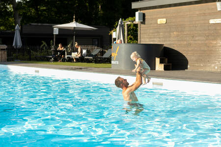 Father with child in the outdoor pool at Soof Retreats Soof Heuvelrug holiday park