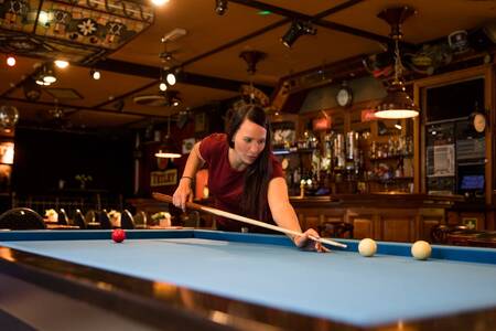 Woman playing billiards in the restaurant of holiday park Topparken Bospark Ede