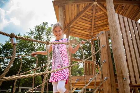 Girl plays on a playground in a playground at the Topparken Parc de IJsselhoeve holiday park