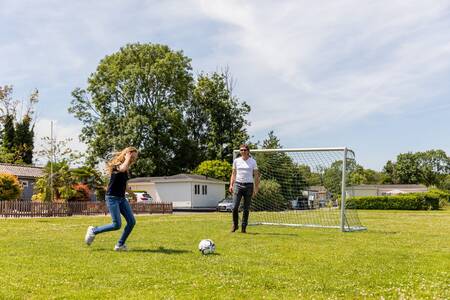 People play football on the playing field at the Topparken Parc de IJsselhoeve holiday park