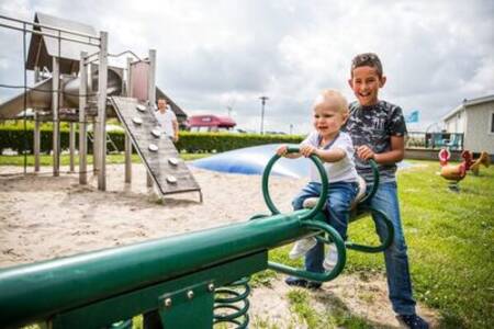 Children on a seesaw in the playground of the Topparken Park Westerkogge holiday park