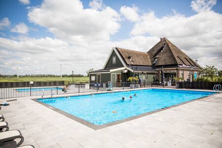 People swim in the outdoor pool with paddling pool of the Topparken Park Westerkogge holiday park