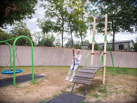 Girl on the cable car in the playground at Topparken Recreatiepark de Wielerbaan