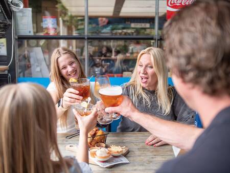 The family enjoys a snack and drink in the restaurant of Topparken Recreatiepark de Wielerbaan