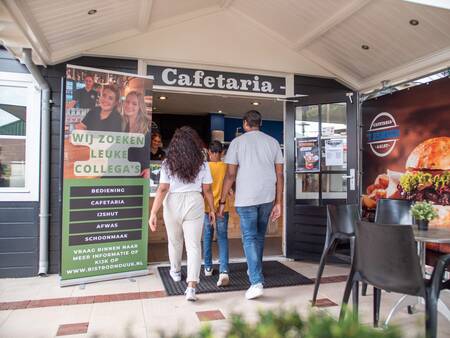 The family enters the cafeteria at the Topparken Recreatiepark het Esmeer