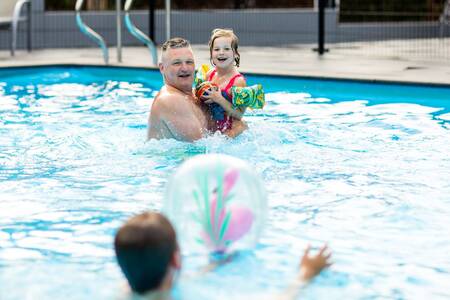 Family swimming in the outdoor pool of holiday park Topparken Recreatiepark Beekbergen