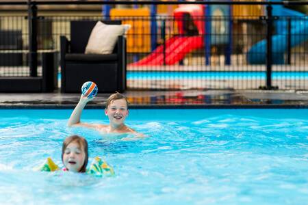 Children swim in the outdoor pool of the Topparken Recreatiepark Beekbergen