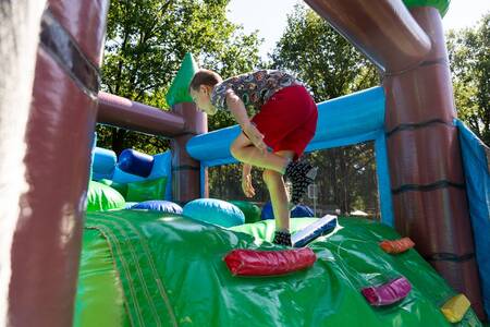 A boy climbs on a climbing cushion at the Topparken Recreatiepark 't Gelloo