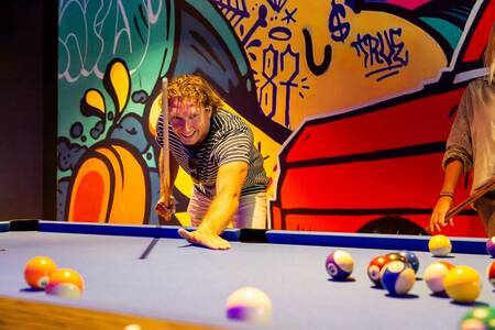 People playing pool in the playroom of the Topparken Resort Veluwe holiday park