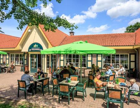 People are sitting on the terrace of the restaurant of the Topparken Resort Veluwe holiday park