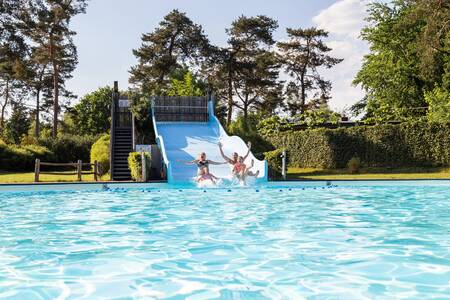 Children slide down the wide slide in the outdoor pool of the Topparken Resort Veluwe holiday park