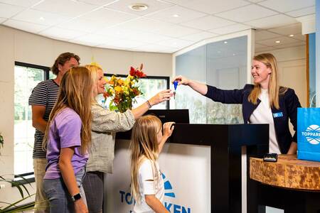 The family receives the key at the reception of the Topparken Resort Veluwe holiday park