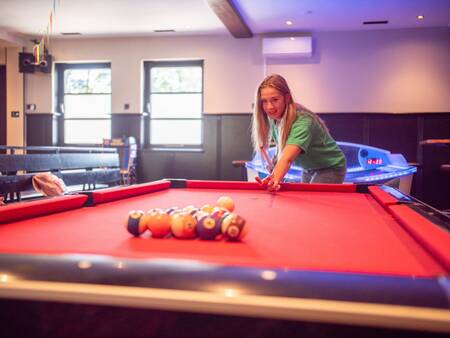 Girl playing pool in the game room of the Topparken Résidence De Leuvert holiday park