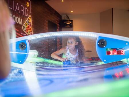 Children play air hockey in the game room of the Topparken Résidence De Leuvert holiday park