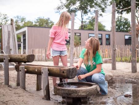Children play with water in a playground at the Topparken Résidence De Leuvert holiday park