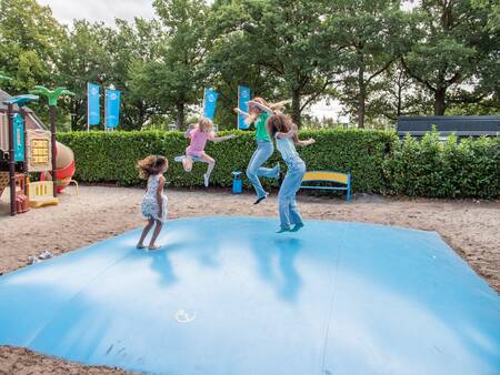 Children jump on an air trampoline in a playground at Topparken Résidence De Leuvert