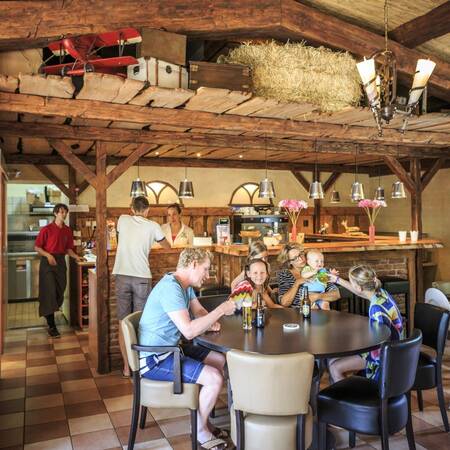 Family having a drink in the restaurant of Veluwecamping De Pampel