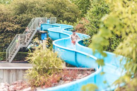 Father with child slides down the slide in the outdoor pool of Veluwepark de Bosgraaf