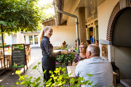People on the terrace of Restaurant De Hazelaer at Villapark Hof van Salland