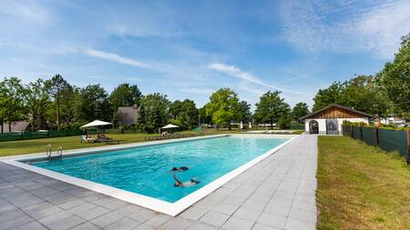 People swim in the outdoor pool of holiday park Villapark Hof van Salland