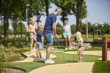 Family playing mini golf on the adventure golf course of De Leistert