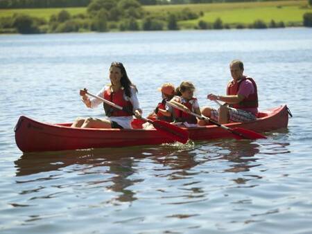 Family is canoeing on the lake at holiday park Landal Village l'Eau d'Heure
