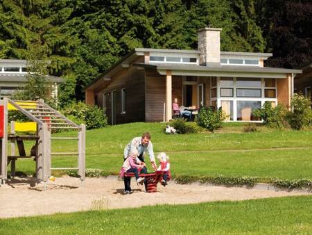 Father with 2 children in the playground at holiday park Landal Village l'Eau d'Heure