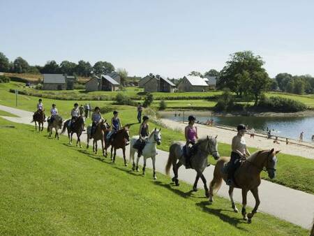 People on horseback riding along the lake at the Landal Village l'Eau d'Heure vakantie holiday park