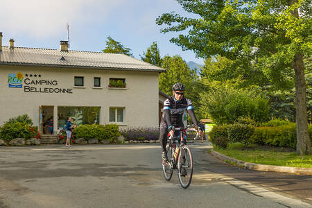 Man cycles in front of the reception of holiday park RCN Belledonne